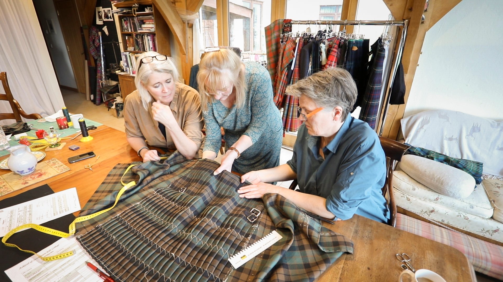 A group of women being instructed on hand tailoring a kilt by Marion foster at the College of Master Kilt Tailors