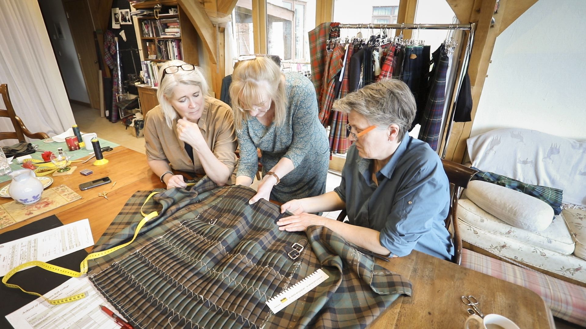 A group of women being instructed on hand tailoring a kilt by Marion foster at the College of Master Kilt Tailors