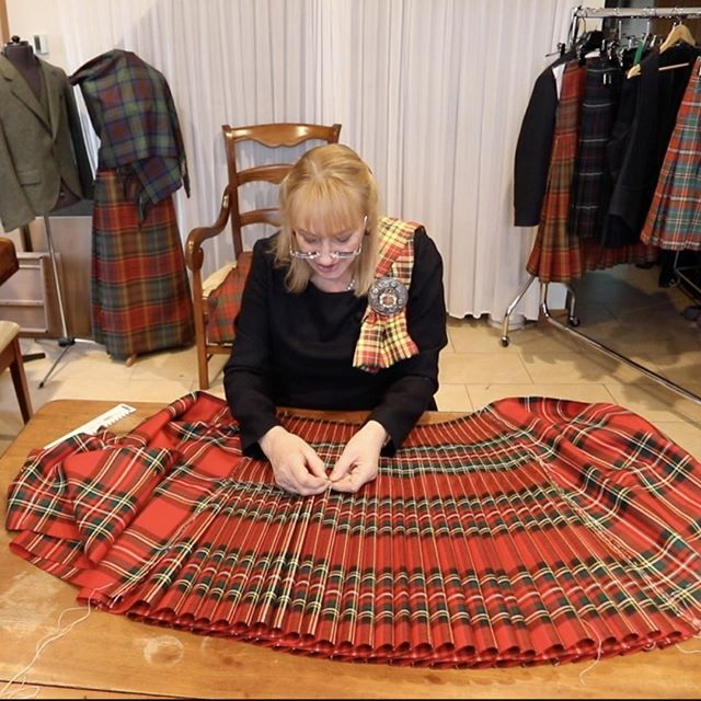 Marion Foster hand tailoring a red kilt at the at the College of Master Kilt Tailors