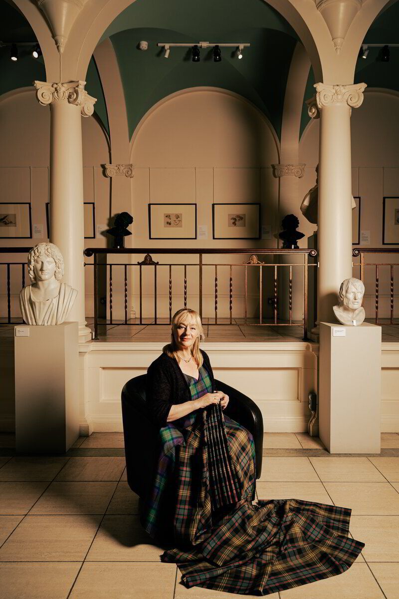 A picture of Marion Foster wearing a hand tailored kilt. Marion is the owner of the College of Master Kilt Tailors.